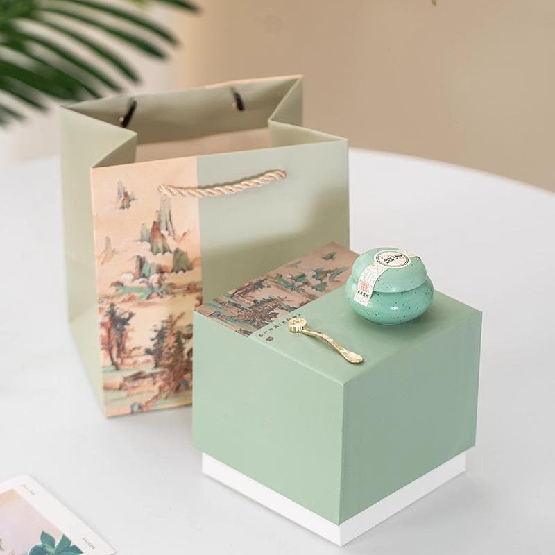 Balm with decorative box and gift bag on a light surface