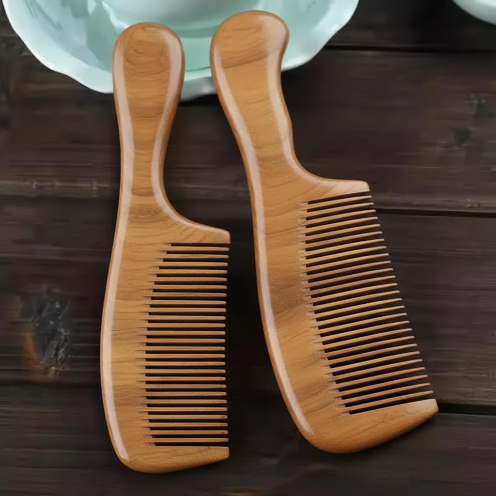 Two wooden combs on a wooden surface with a blurred background