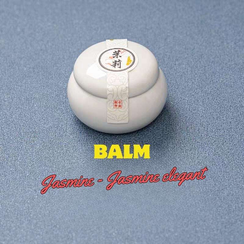 White balm container with a label on a gray background, labeled 'Balm Jasmine - Jasmine elegant'.