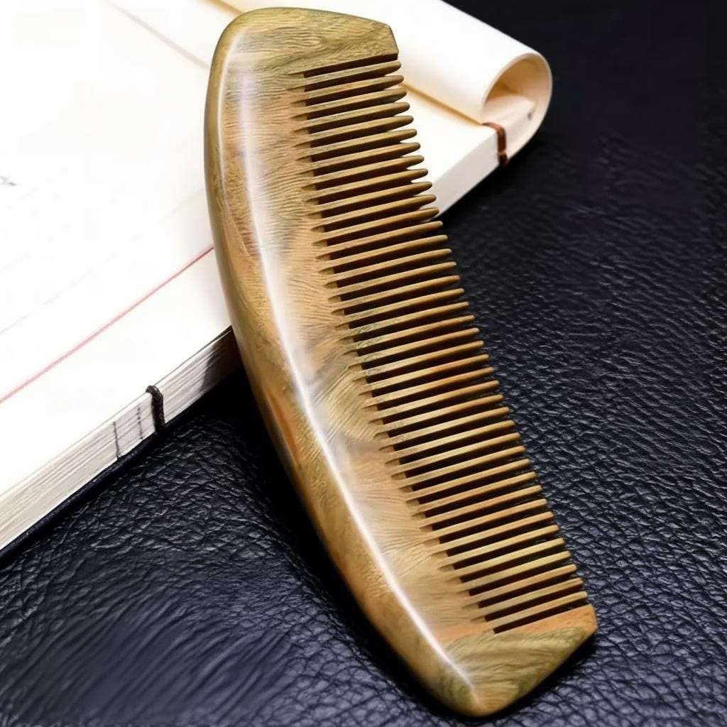 Wooden comb on a textured black surface with a white background