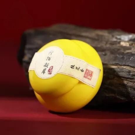 Yellow balm with a label on a dark surface