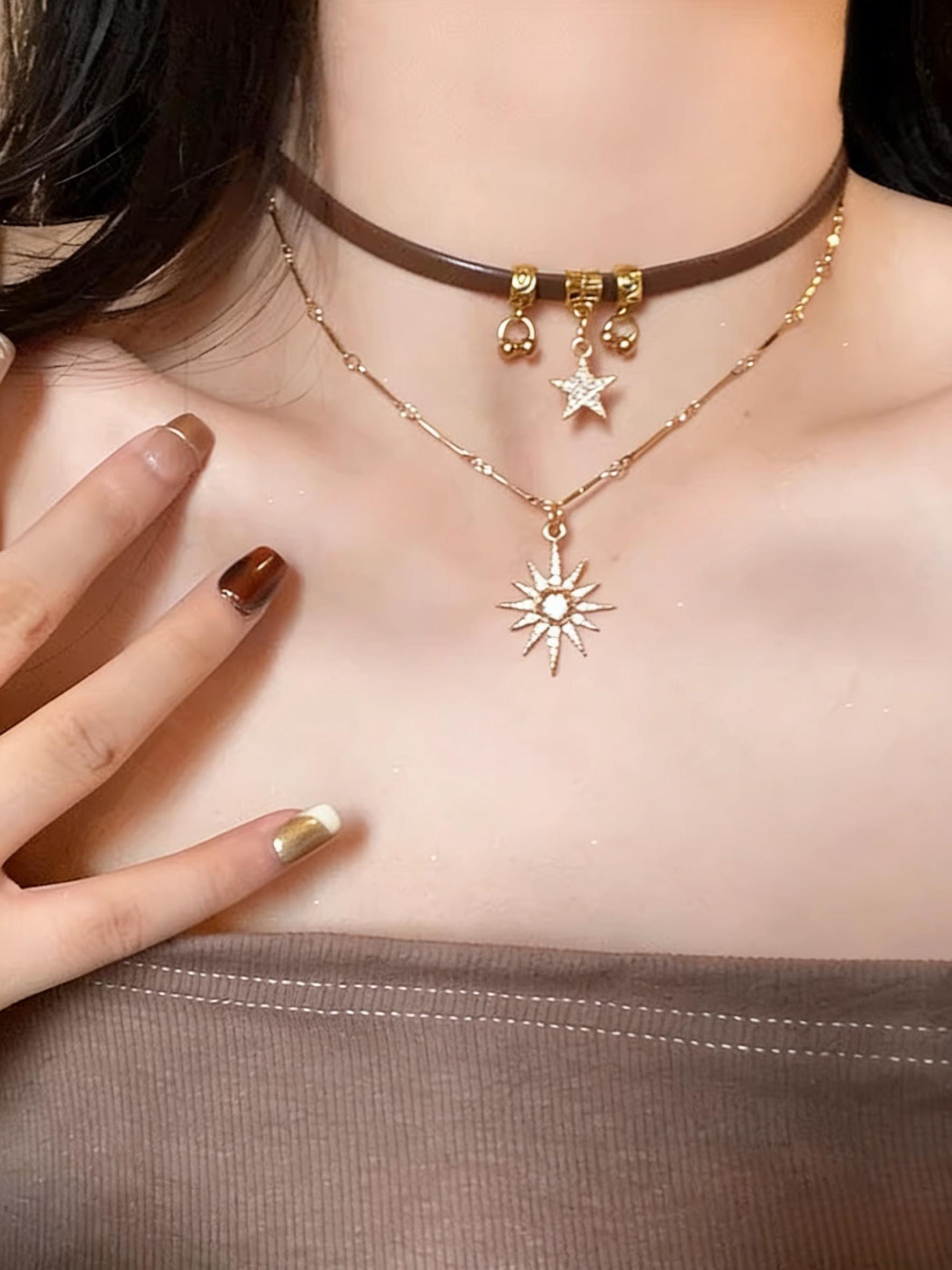 Necklace with star and sun pendant worn by a person