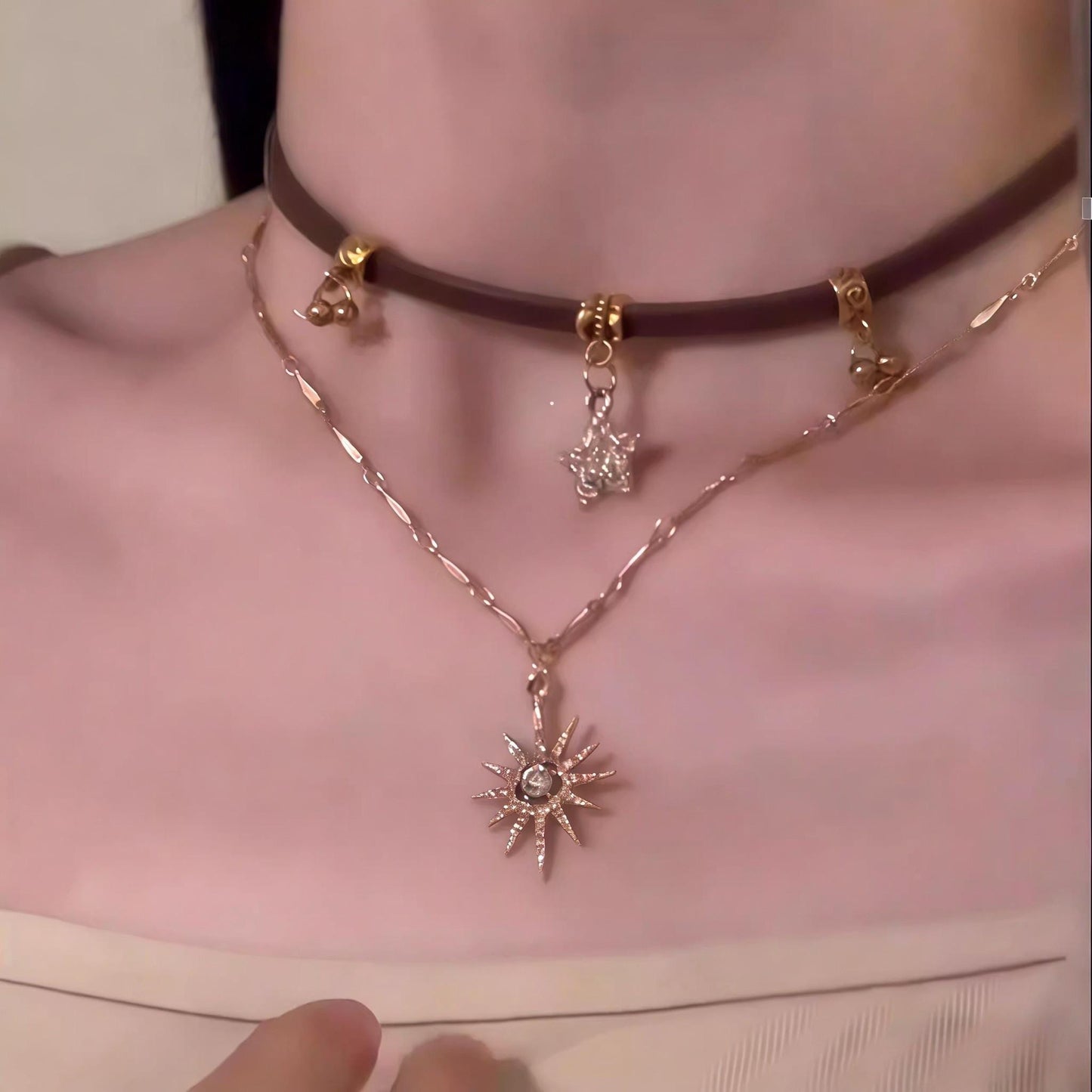 Necklace with sun-shaped pendant worn by a person