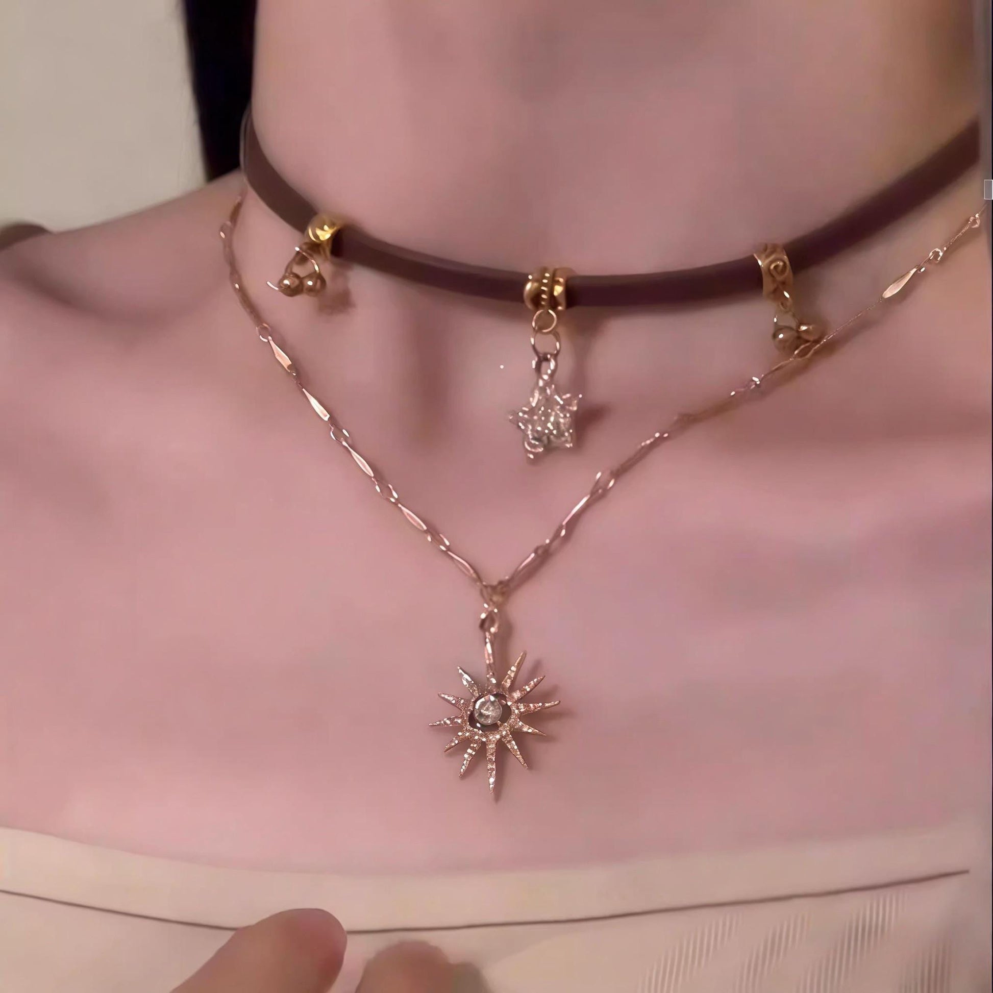 Necklace with sun-shaped pendant worn by a person
