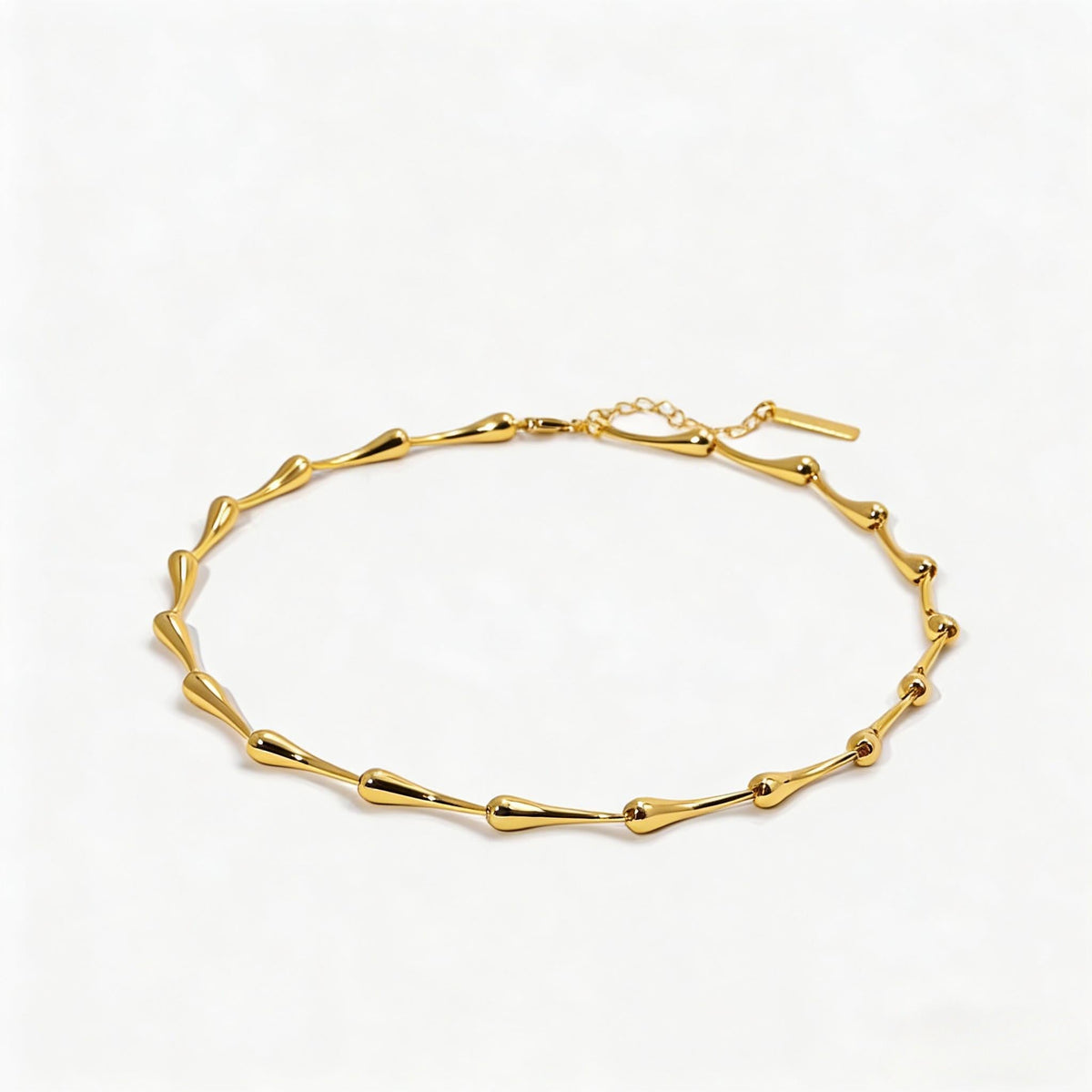 Close-up of bamboo water drop chain detail on gold sweater necklace