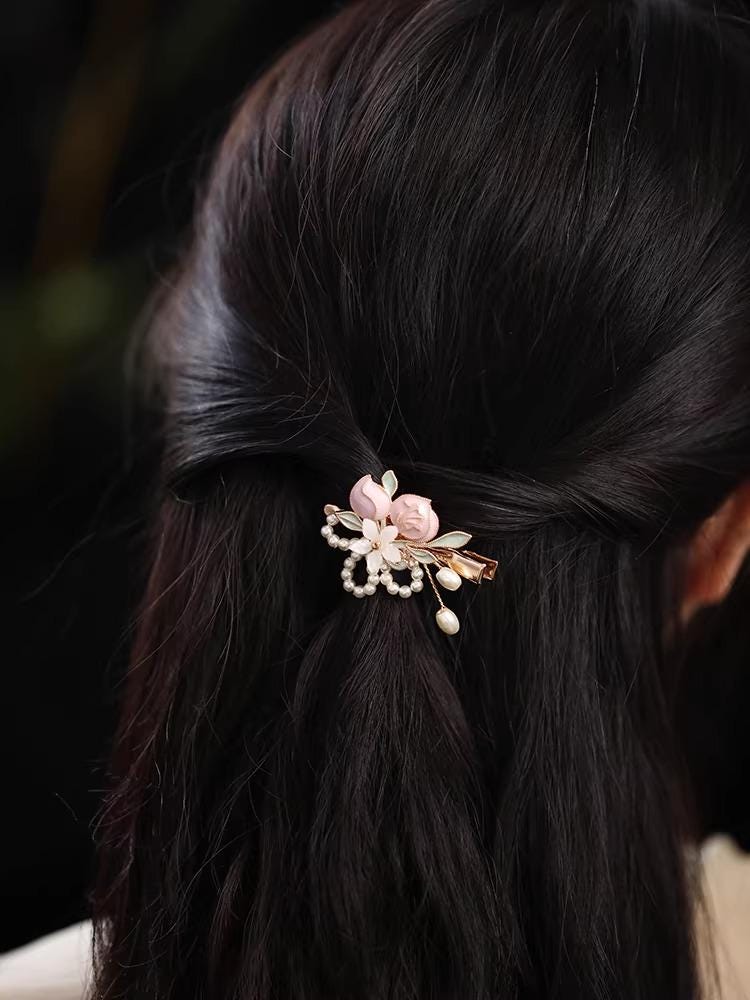 Decorative hair clip with flowers in dark hair against a dark background