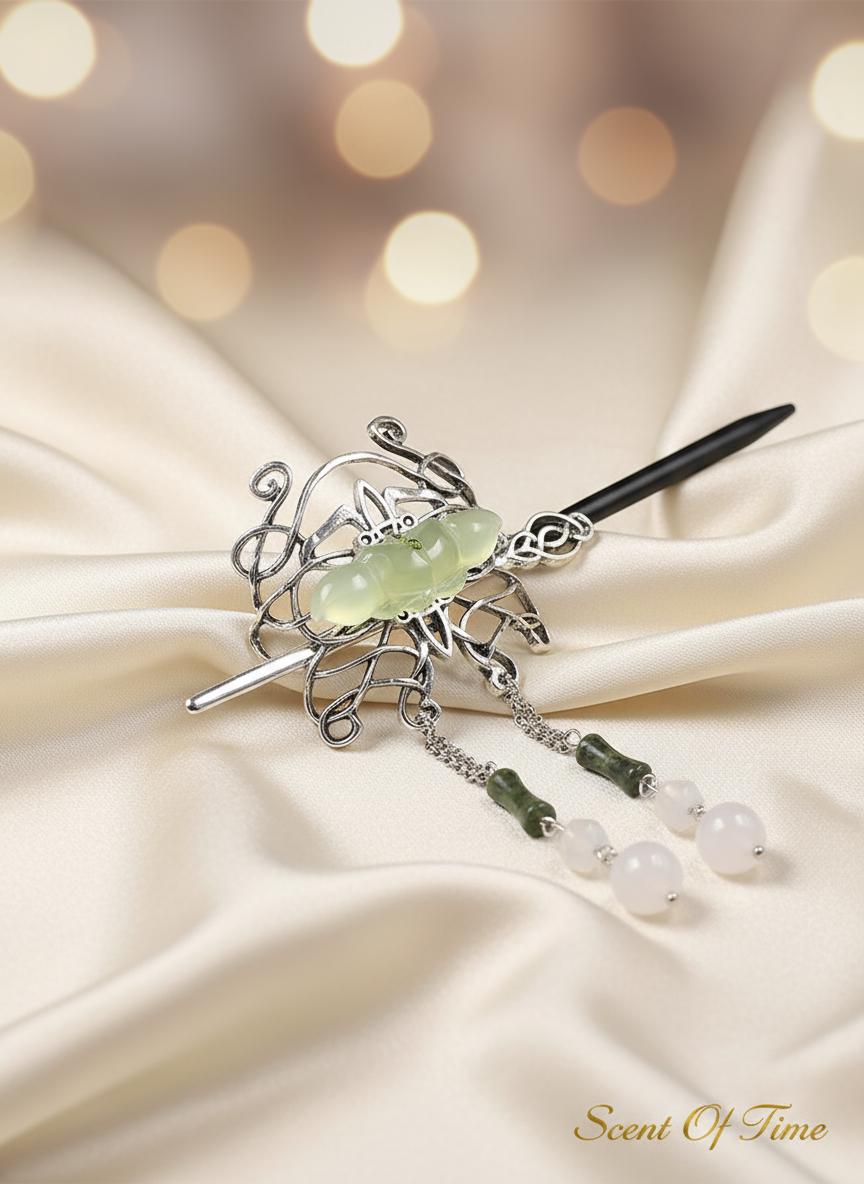 Decorative hair clip with green stone and beads on a satin background