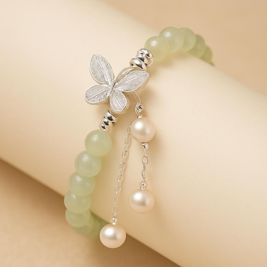 Bracelet with butterfly charm and pearl beads on a beige background