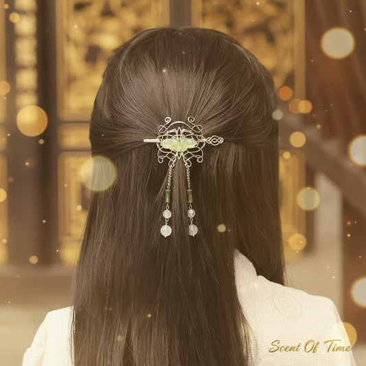 Person with intricate hair clip in dark hair against a blurred golden background