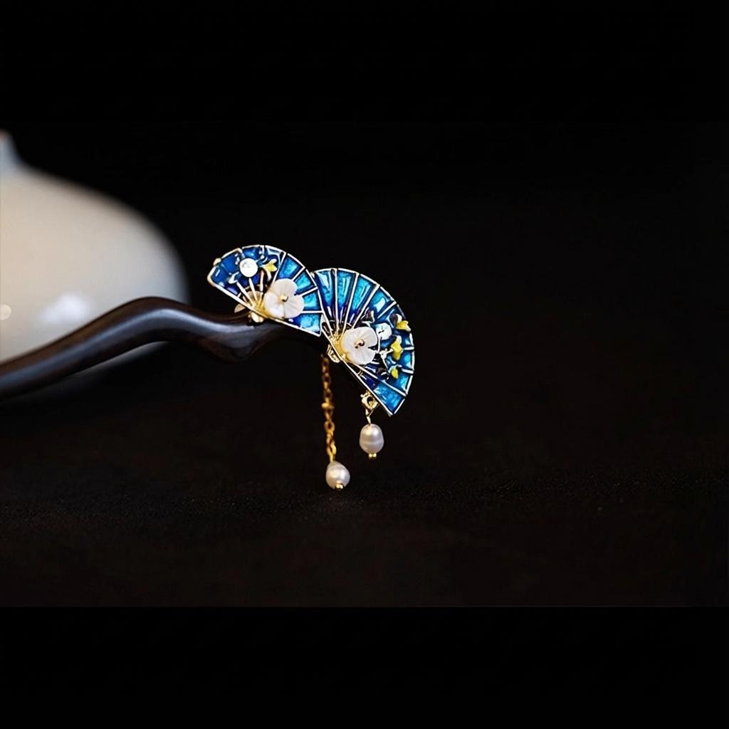 Decorative earrings with blue fan design and pearl accents on a dark background