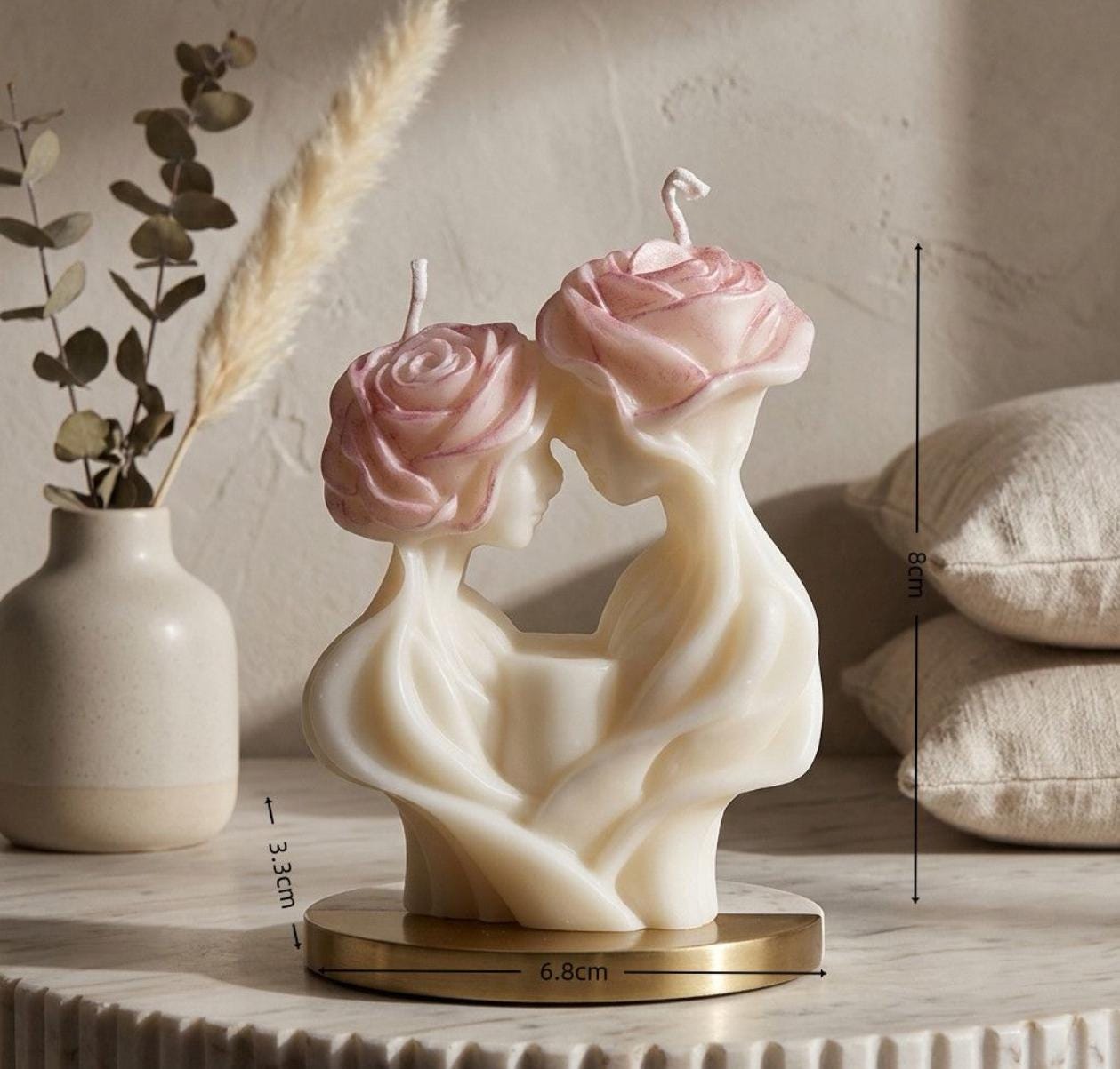 Decorative candle with rose design on a wooden surface with a neutral background