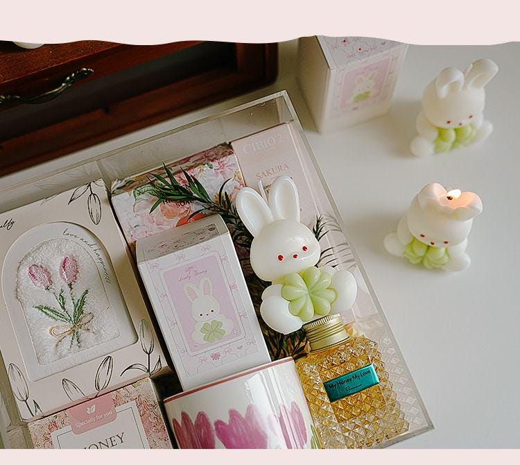 Decorative items including a rabbit-shaped bottle, cards, and candles on a table.
