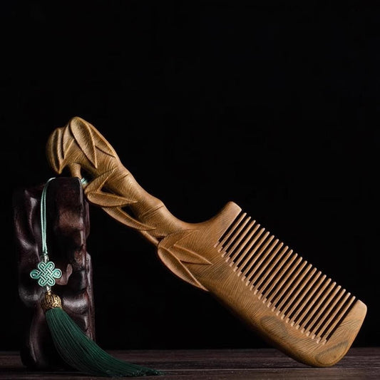 Wooden comb with decorative tassel on a dark background